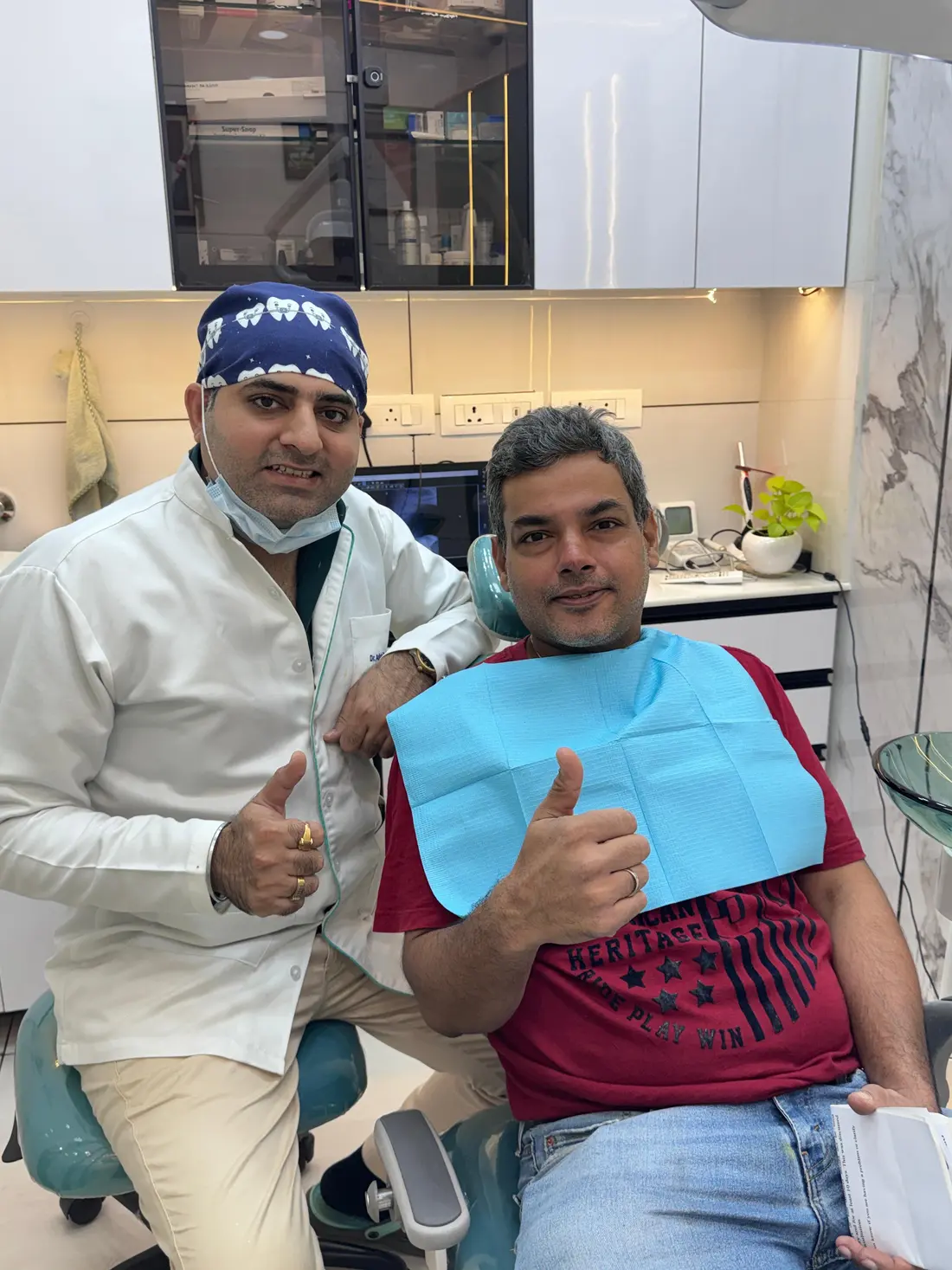 A dentist and a visitor beside a dental chair at Petal Smiles